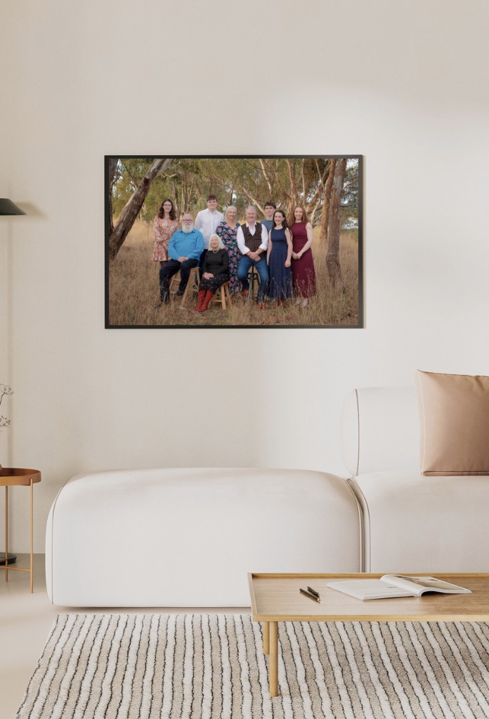 Framed extended family portrait hanging above a sofa in a living room