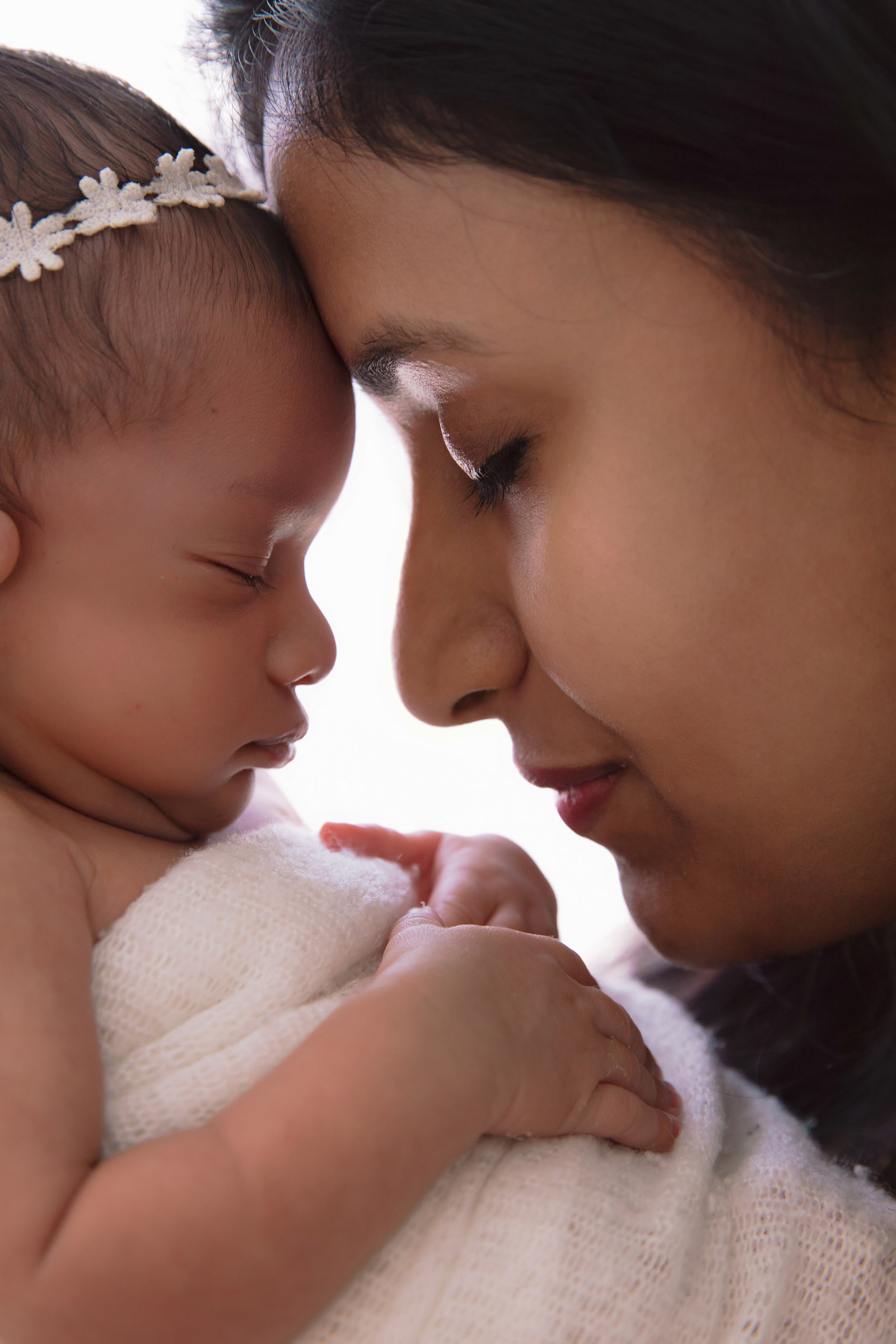 Mother holding her newborn baby in soft natural light
